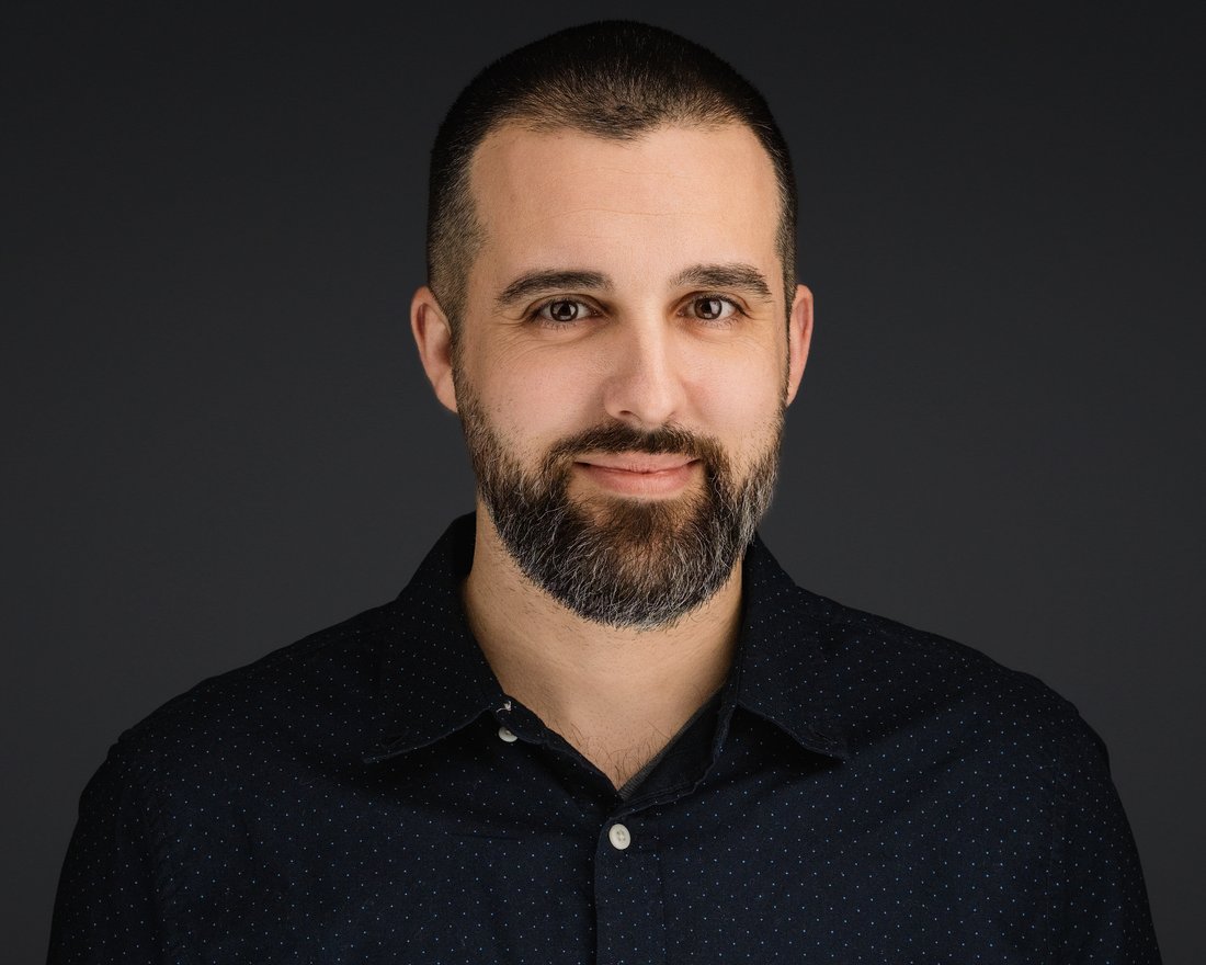 Individual headshot of a bearded man in a dark shirt, photographed on location in Maryland